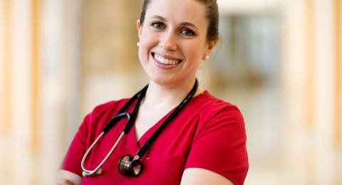 Smiling Health Care professional in a red scrubs shirt and stethoscope